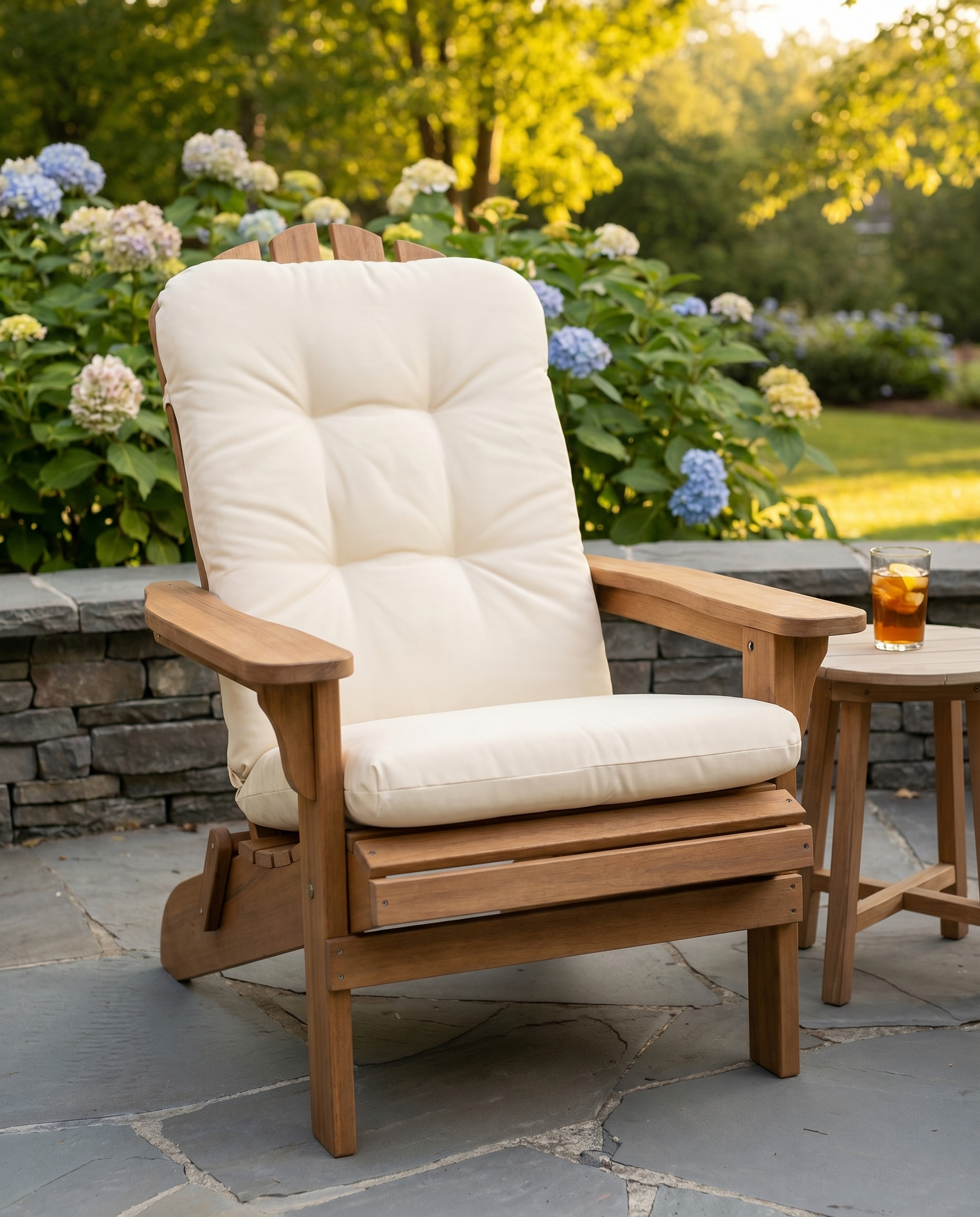 Cream tufted Adirondack chair cushion on a teak chair in a sunny garden