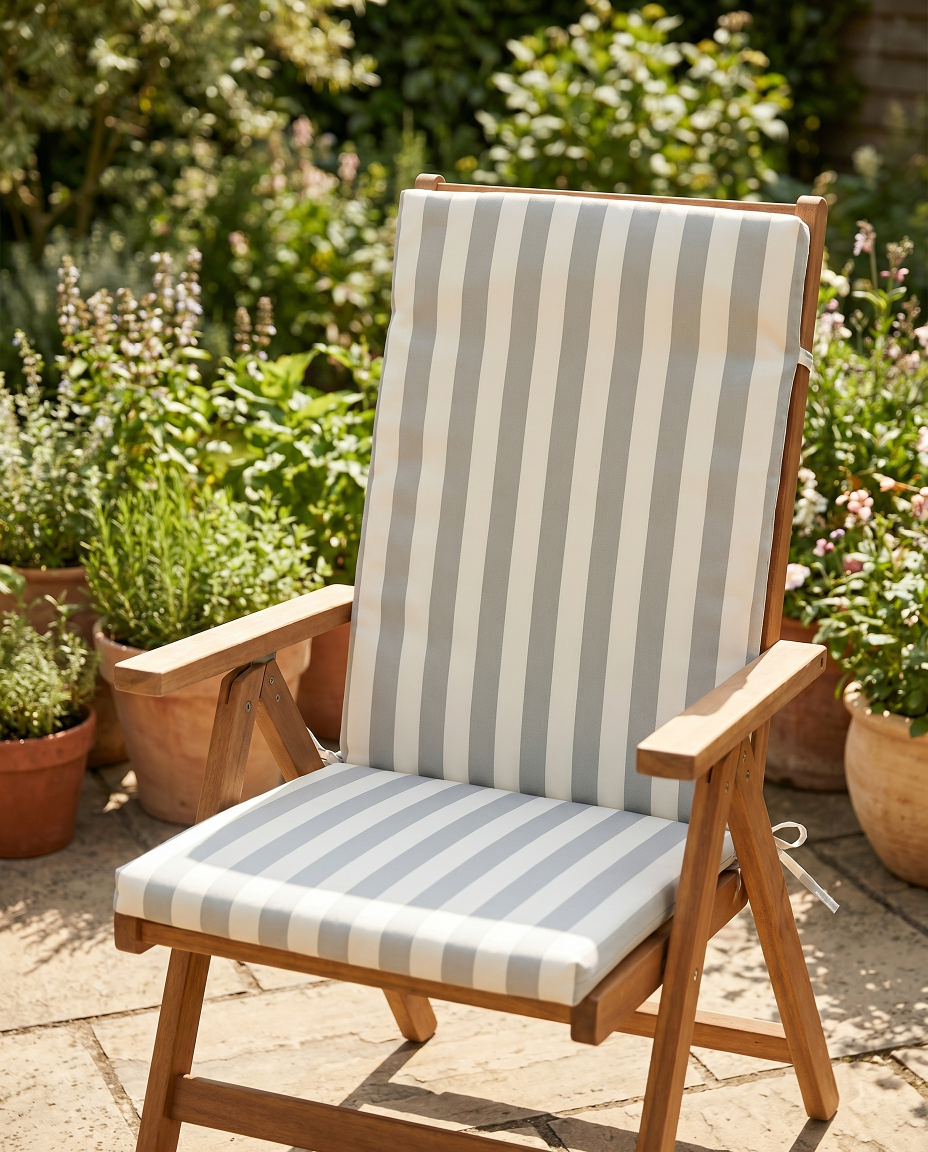 Grey and cream striped high-back chair cushion on a folding garden chair