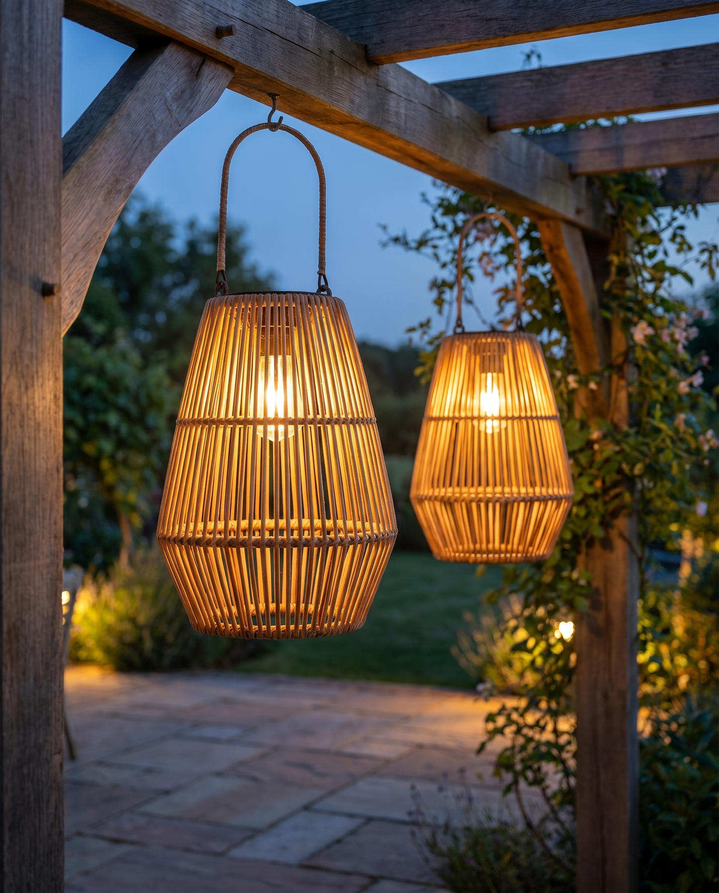Rattan solar hanging lanterns glowing from a pergola at dusk