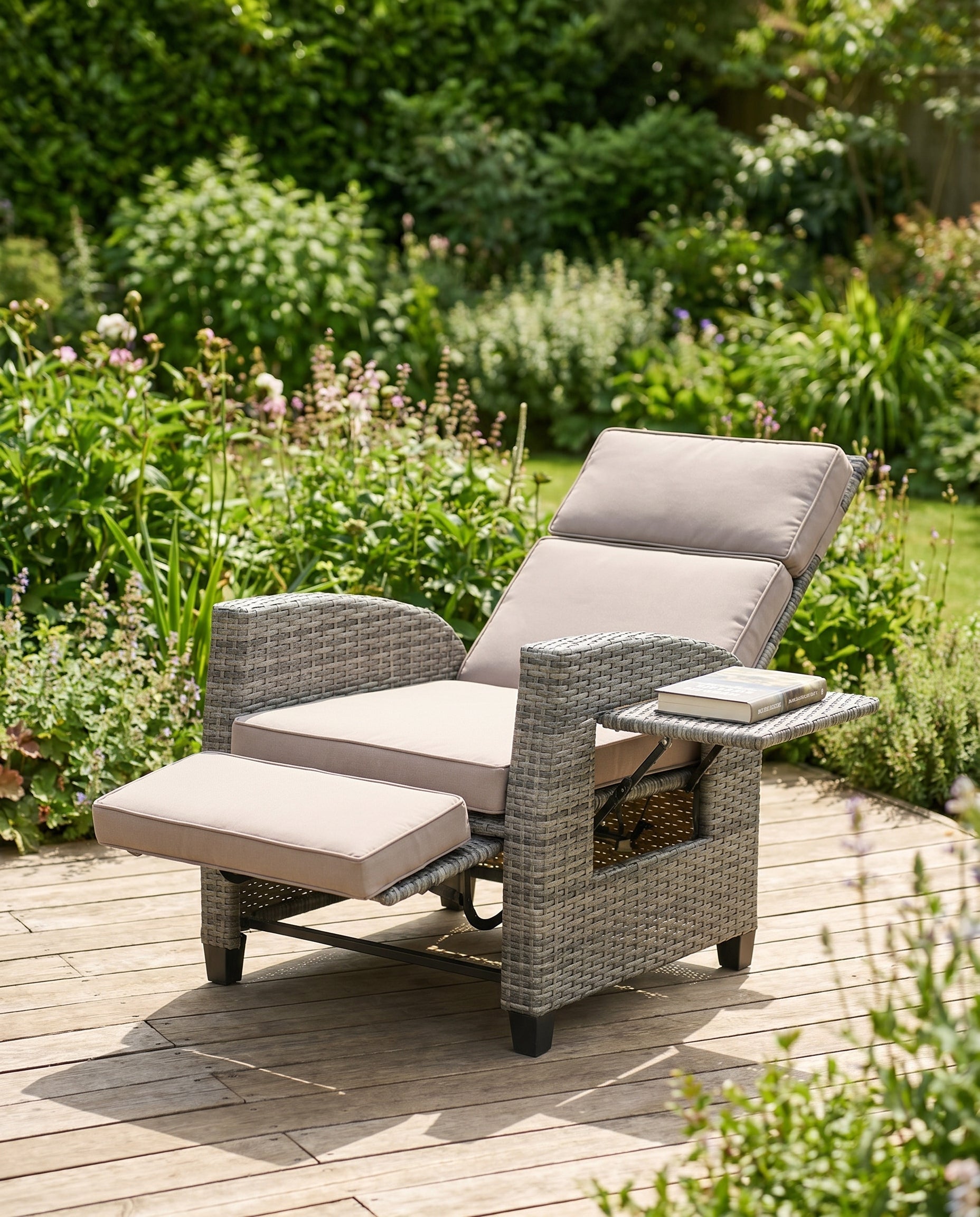 All-weather grey wicker patio recliner with footrest on a garden deck