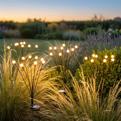 Solar firefly stake lights among ornamental grasses at dusk, square
