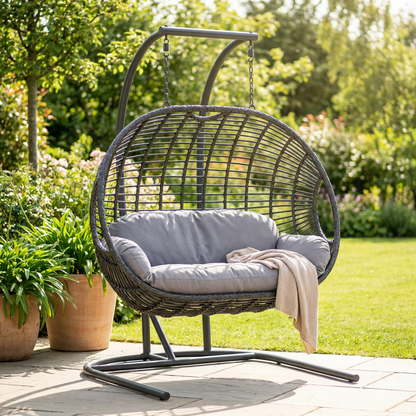 Hanging egg chair with steel stand and cushion on a garden patio